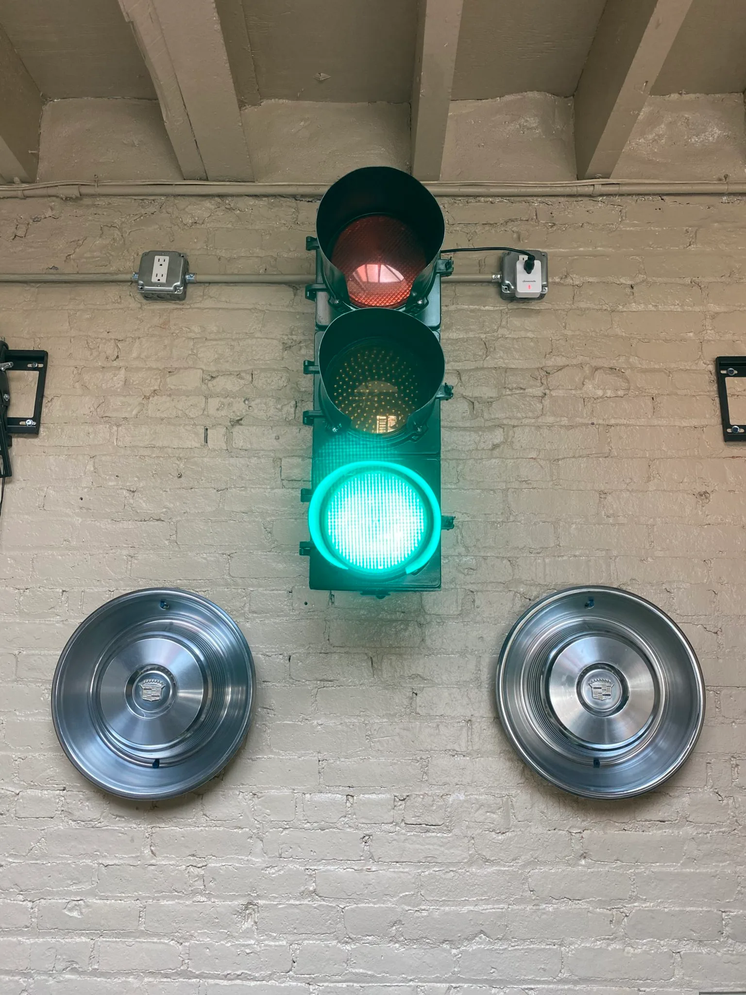 A vintage traffic light and chrome hubcaps on the brick wall inside The Beer Garage Park Slope in Brooklyn